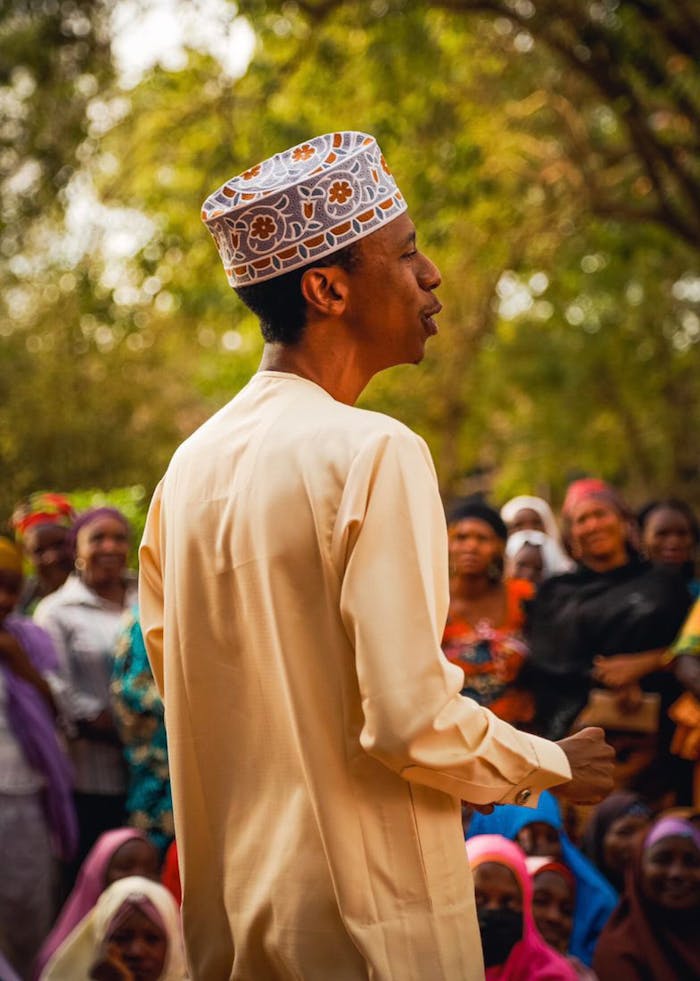 Leading with compassion and wisdom, Khalil Nur Khalil connects with his community under the shade of nature, fostering understanding and unity.